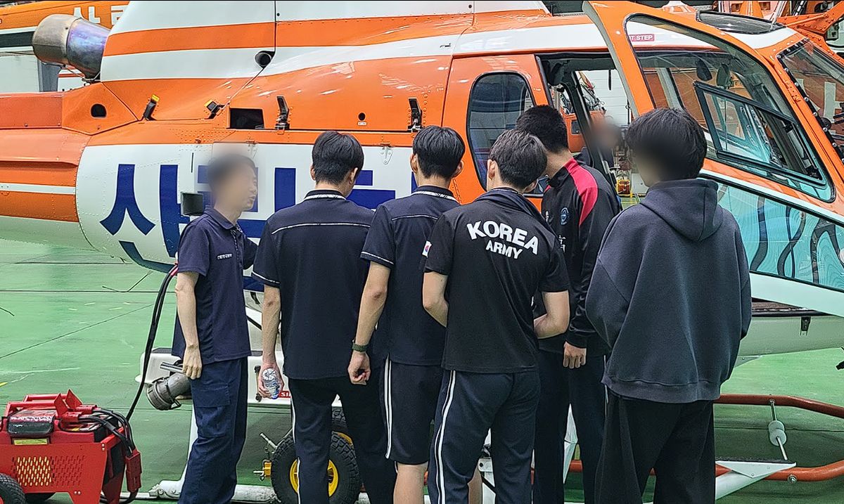 공공기관 진로체험 — 헬기 앞에서 설명 듣는 학생들 (얼굴 흐림 처리)